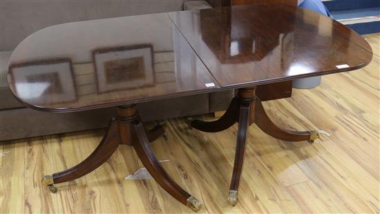 A Regency style mahogany extending twin pillar dining table, L.165cm plus two leaves each 46cm.